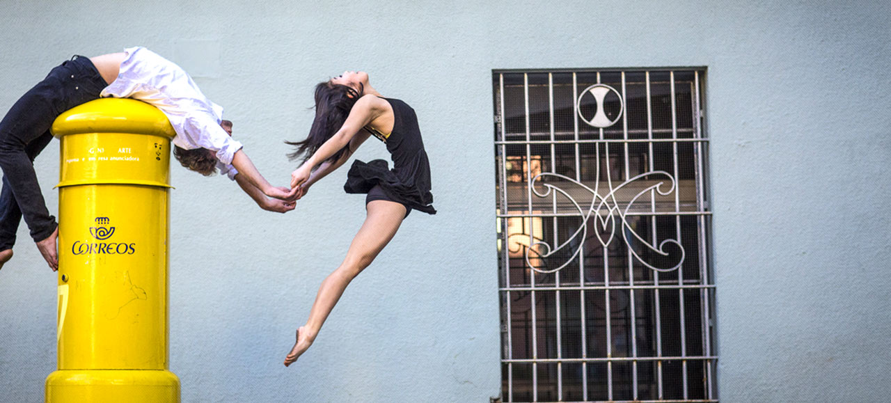 A dancer in silhouette against a city backdrop